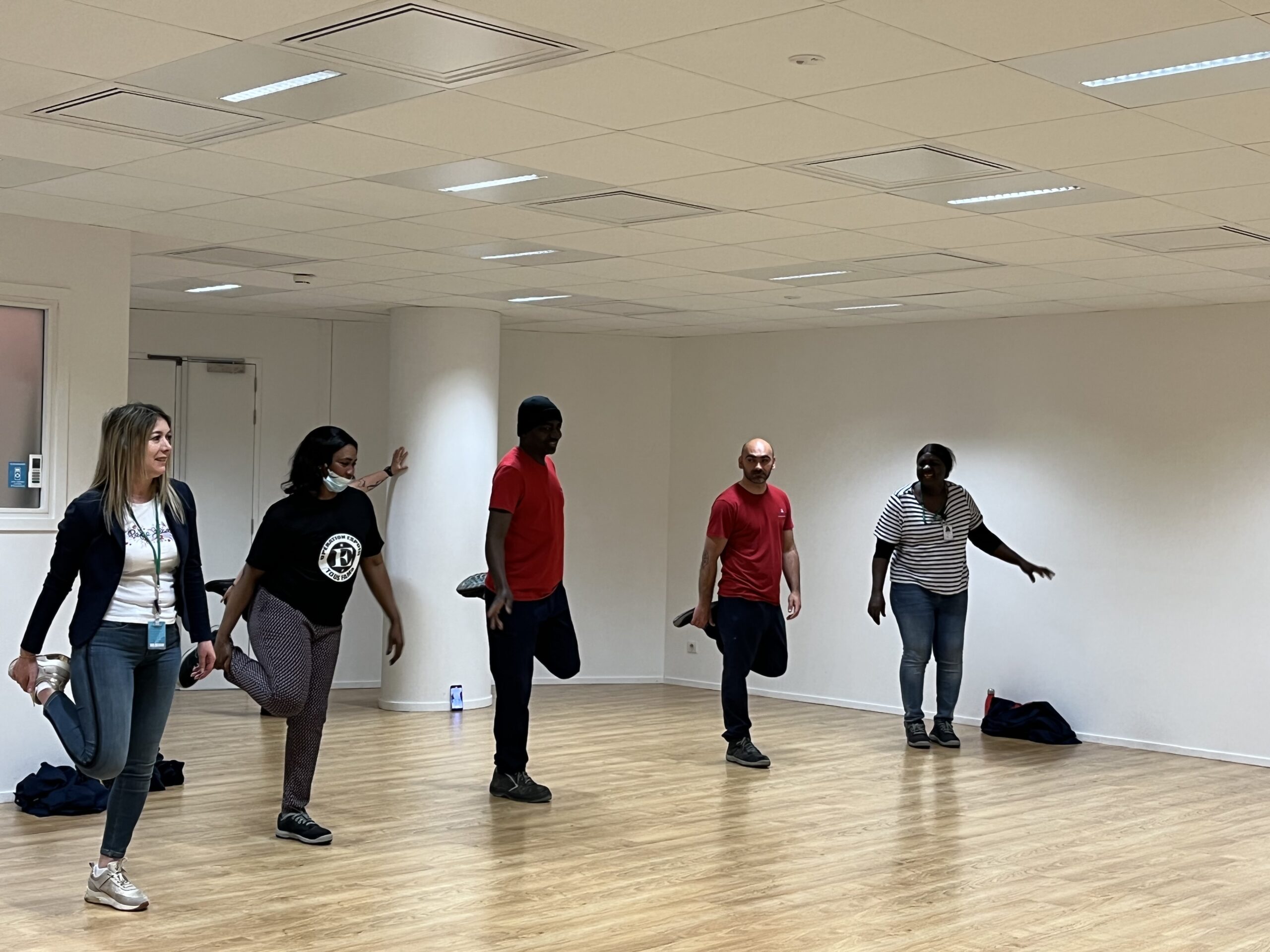 Photo de groupe de l'une des équipes ISOR Group sur site client, en train de réaliser des étirements de réveil musculaire