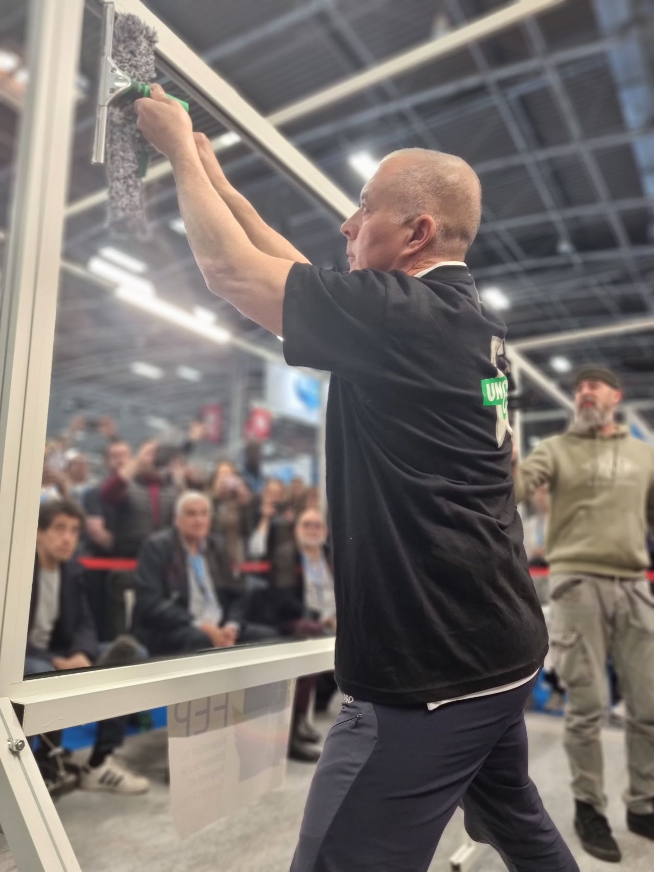Homme en train de participer au concourt de laveur de vitre, sur le salon Europropre 2024